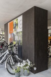 FB49 Sherwood open wandkast in fietsenwinkel decoratief plaatmateriaal donker grijs gebeitst houtdecor.