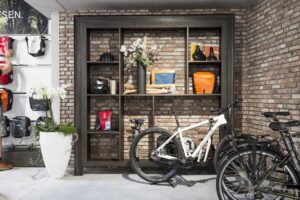 FB49 Sherwood open wandkast in fietsenwinkel decoratief plaatmateriaal donker grijs gebeitst houtdecor.