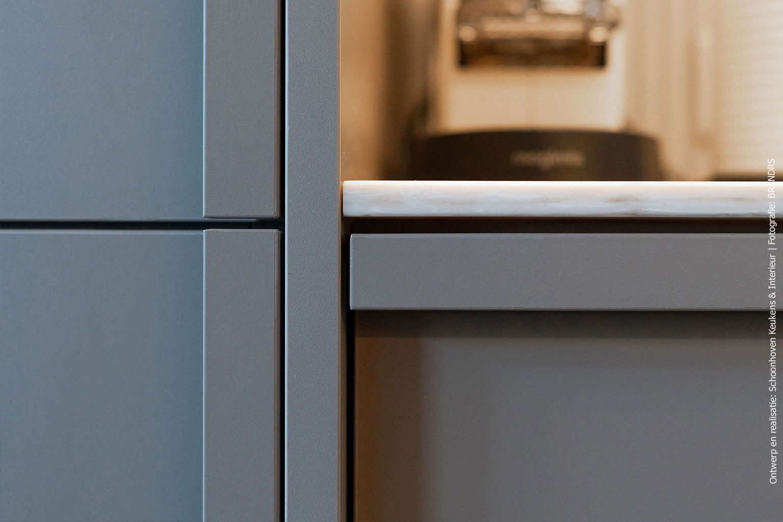 Detailfoto van een keuken met kasten in de taupe UA94 DECObasic en een solid surface blad in DM5002 Weathered Wood