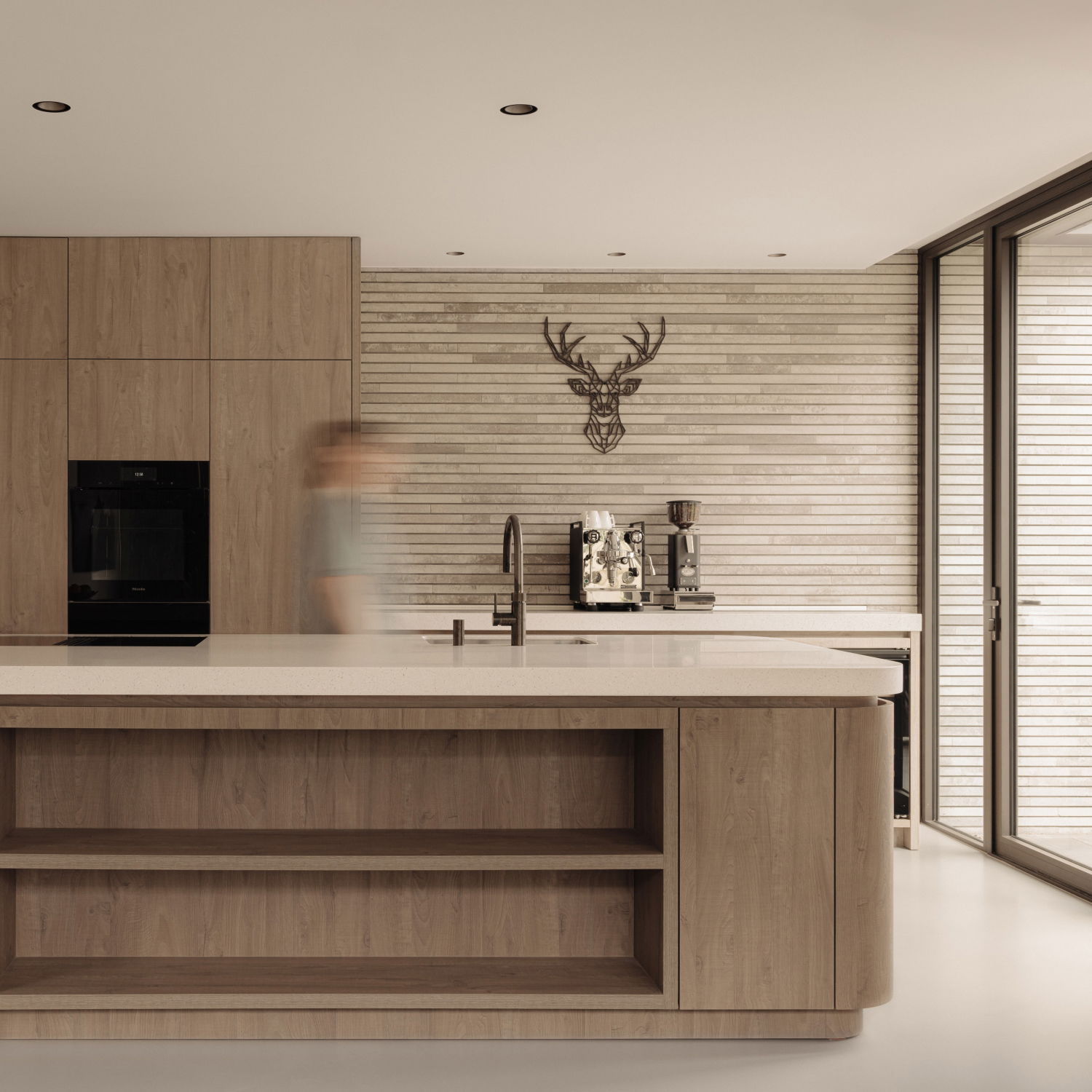 Een moderne keuken met ronde vormen in decoratief plaatmateriaal in de mat bruine S076 Sherwood perfect gecombineerd met het gekorrelde decor van het solid surface materiaal TS070 Gadthena